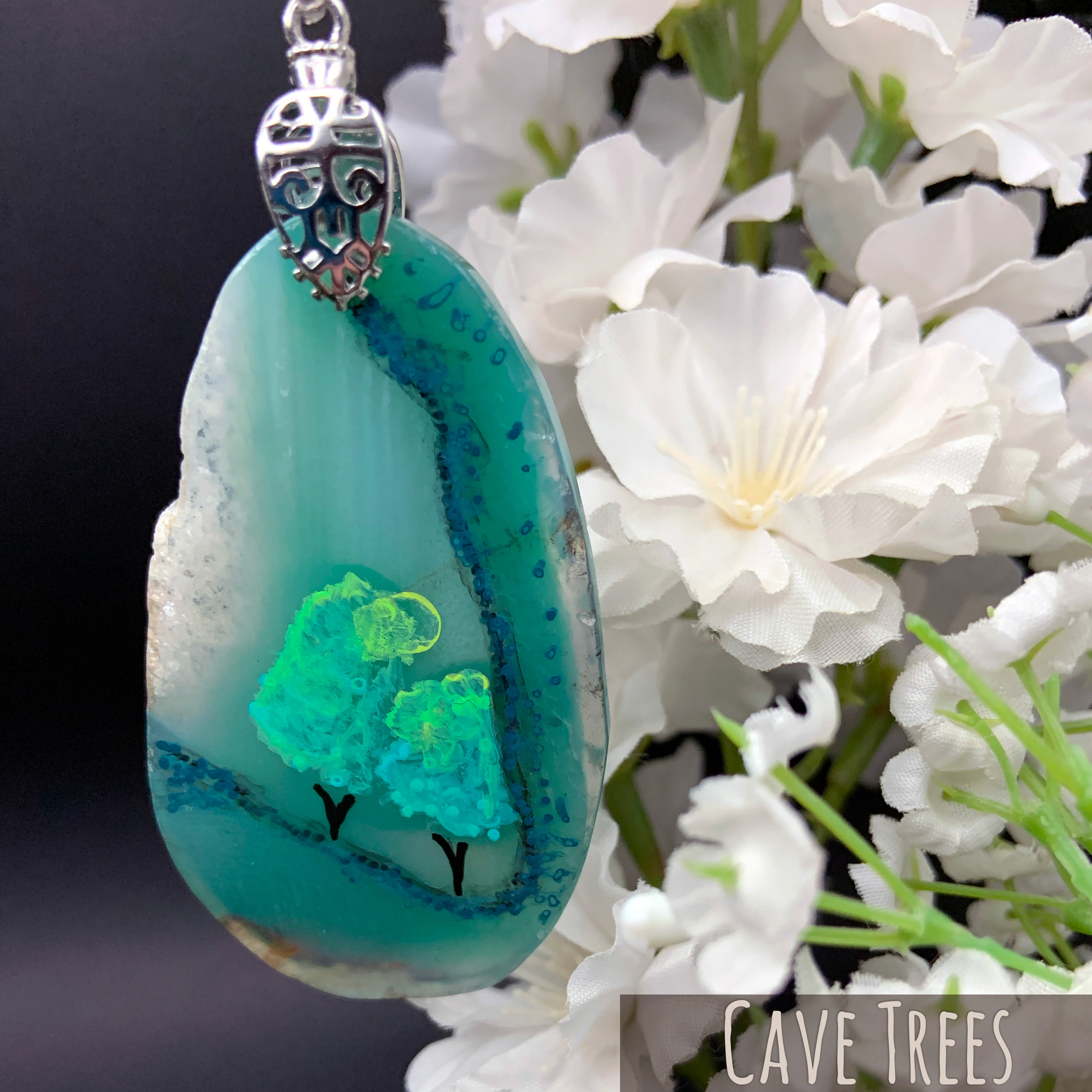 One-of-a-kind hand-painted natural teal dyed agate slice with two trees viewd from a cave behind a waterfall